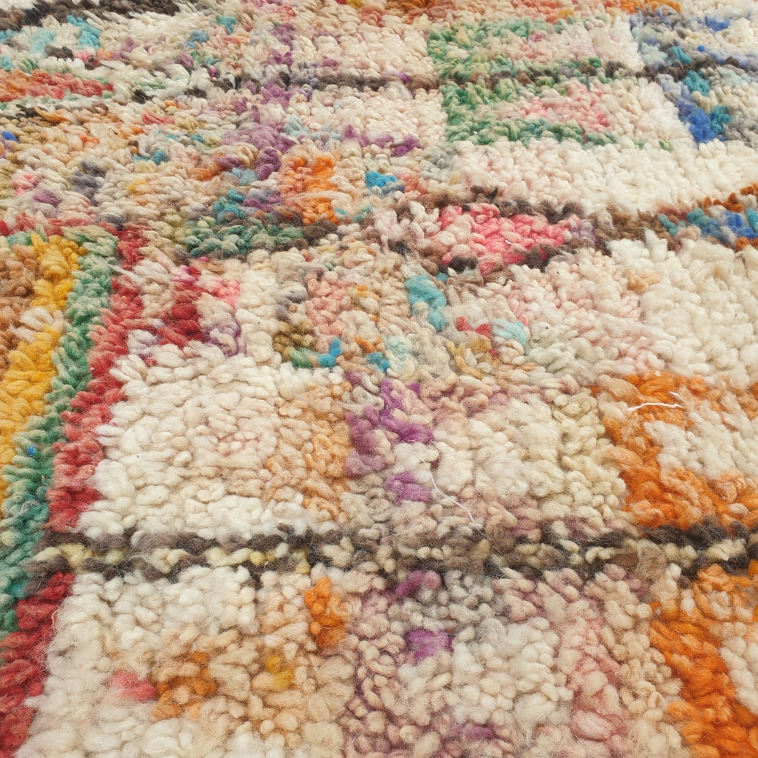 Close-up of a Yaftna Moroccan rug showing the soft wool pile with the dense multicolor confetti pattern - flecks of turquoise, orange, pink and blue scattered across the ivory ground, handwoven in 100% wool