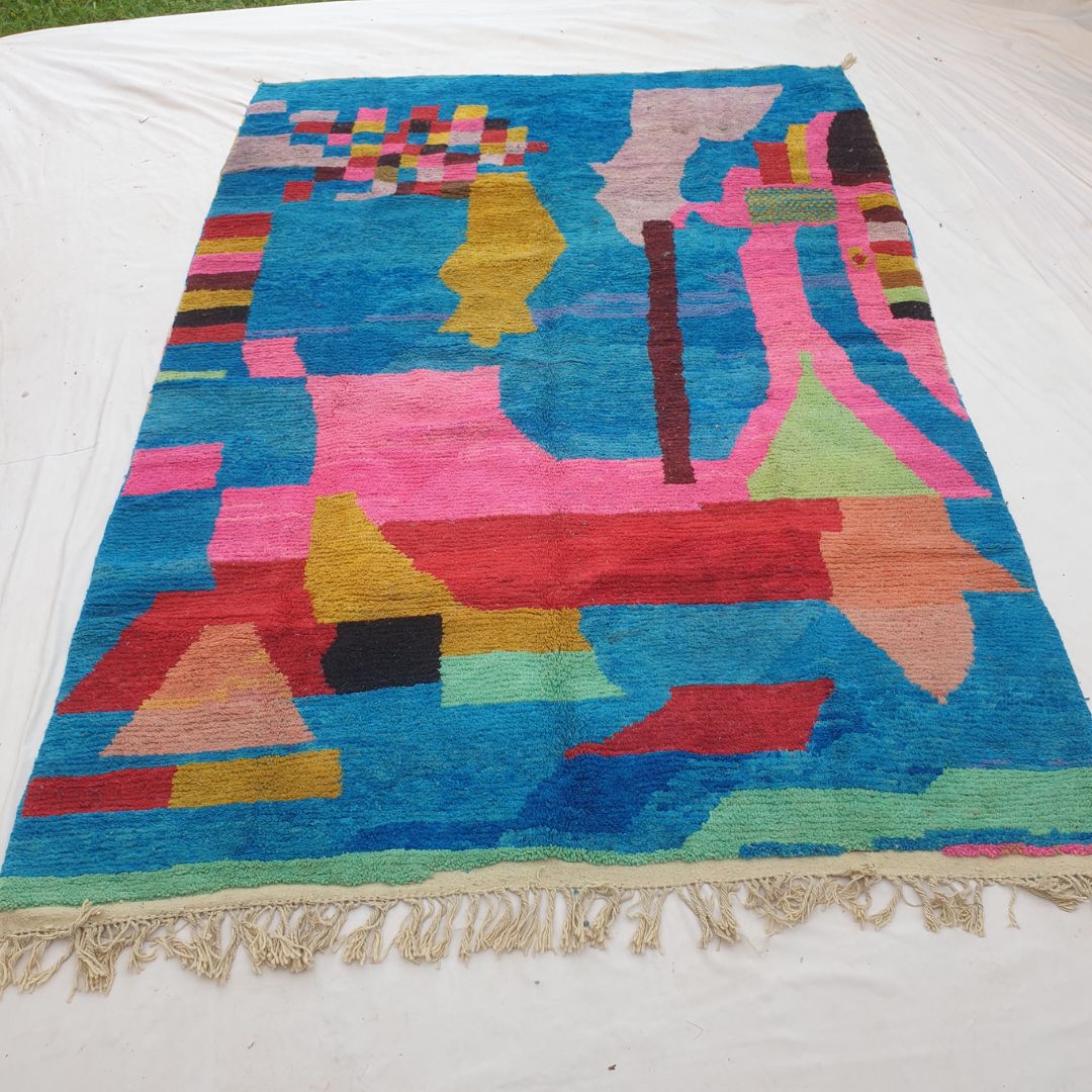 Authentic Boujad Moroccan rug 257×360 cm laid flat — electric cobalt blue background with large bold abstract geometric shapes in hot pink, red, mustard yellow, lime green, lavender, salmon and black, handmade in Morocco by Berber women, a unique piece of floor art