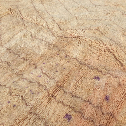 Detailed view of subtle purple accents and yellow geometric motifs against the pale nude pink and beige background of this fluffy Berber shag rug