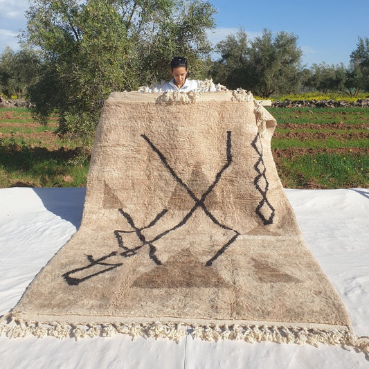 Soft 6x9 Beni Ourain Moroccan rug in ivory with bold black diamond lines and abstract X motifs ultra thick plush pile held outdoors