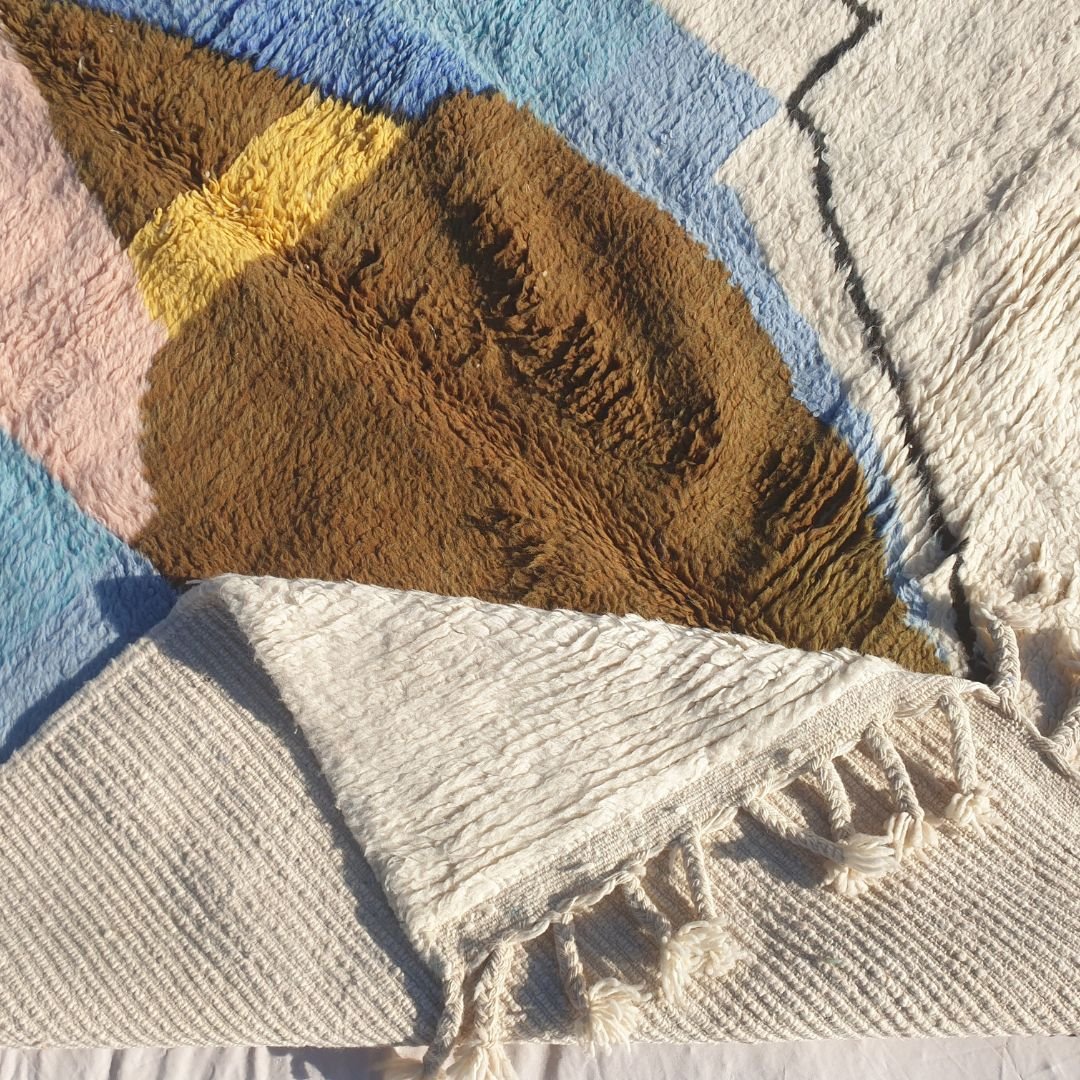 Hand-knotted fringe and outlined border in creamy ivory framing the vibrant geometric design of 6x9 Beni Ourain Moroccan rug