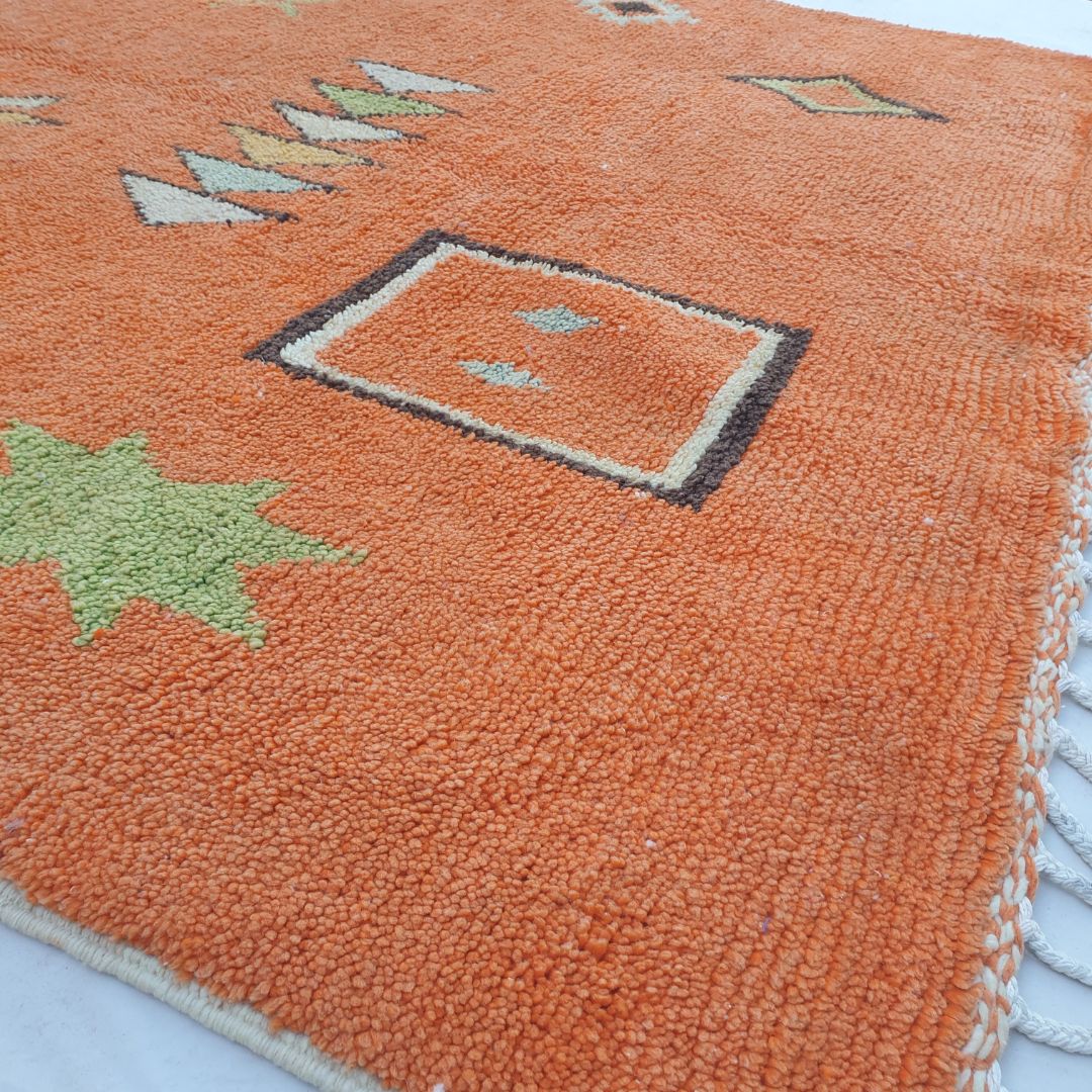 Soft plush wool pile texture and rich natural color variations of authentic orange Boujad Berber rug with tribal embroidery