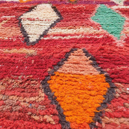 Detailed handwoven Berber diamond motifs and abstract geometric shapes in rich red, orange, pink, teal and blue on authentic Boujad Moroccan rug