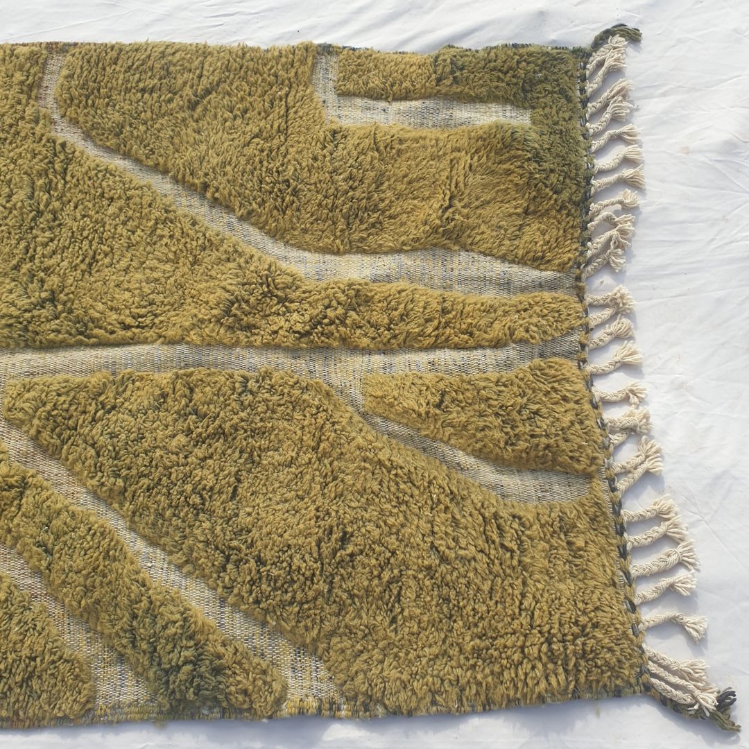 Detail shot of the abstract organic ivory branching line composition on Kwata olive green Beni Ourain rug - the fluid lines sweeping across the warm olive green wool field, a naturalistic abstract composition of organic movement and botanical energy entirely in natural wool