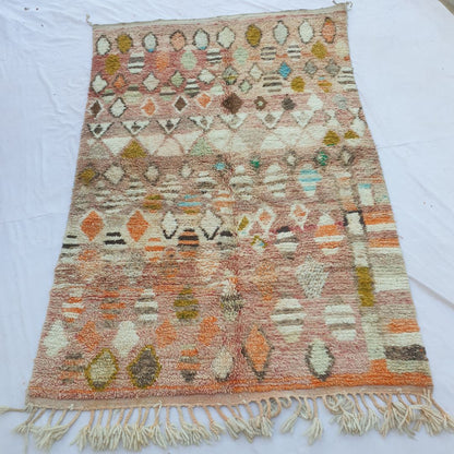 handwoven Boujaad Berber rug (188x315 cm) laid flat, warm rose-pink and terracotta ground densely covered in scattered diamond and oval tribal motifs in ivory, mustard, teal, orange and brown.