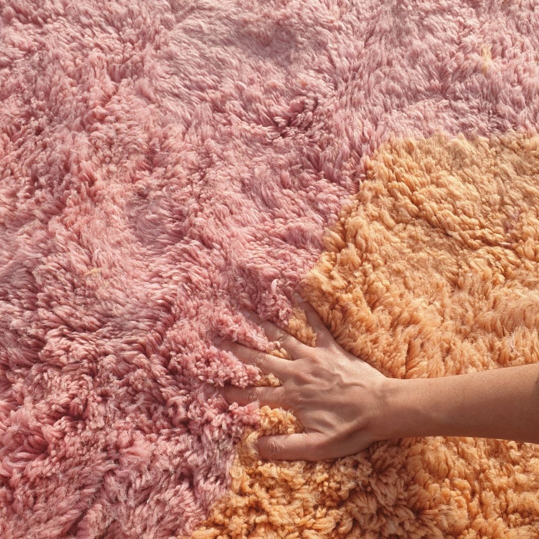 Close-up of dense thick shag pile and soft natural wool texture on handmade Beni Mrirt pink and orange rug
