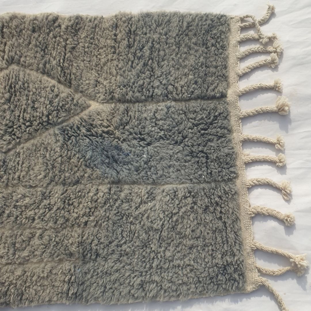 Detail shot of the abstract line art on Minayta grey taupe Beni Ourain accent rug - the asymmetric stepped frame and diamond motif in dark tones against the muted grey taupe wool, an architectural sketch quality scaled for a small accent piece