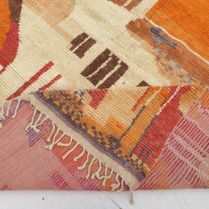 Hand-knotted fringe and detailed border in warm earthy tones framing the bold vibrant geometric tribal design on 9x12 large Boujad Moroccan rug