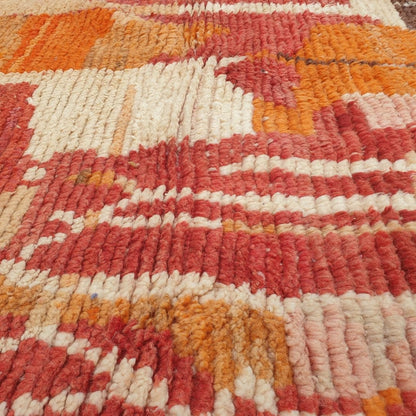 Detailed handwoven Berber abstract motifs including large freeform shapes, vertical lines, diamonds and symbolic elements in rich orange, red, pink, yellow and blue on authentic Boujad Moroccan rug