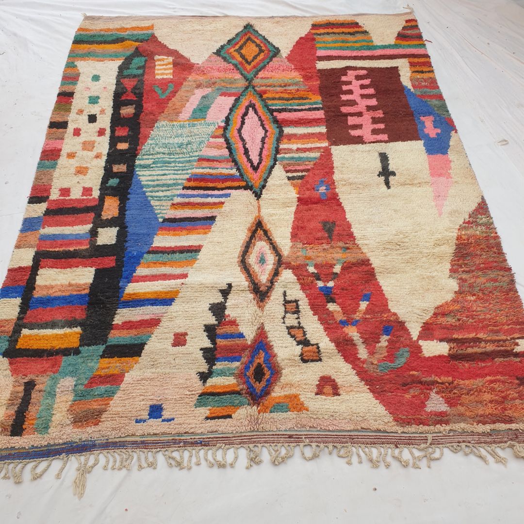 Authentic Boujad Moroccan rug 296×388 cm laid flat — ivory cream background with a vertical column of multicolor diamond medallions and vivid abstract colorful sections in cobalt blue, red, teal, orange and pink, handmade in Morocco by Berber women