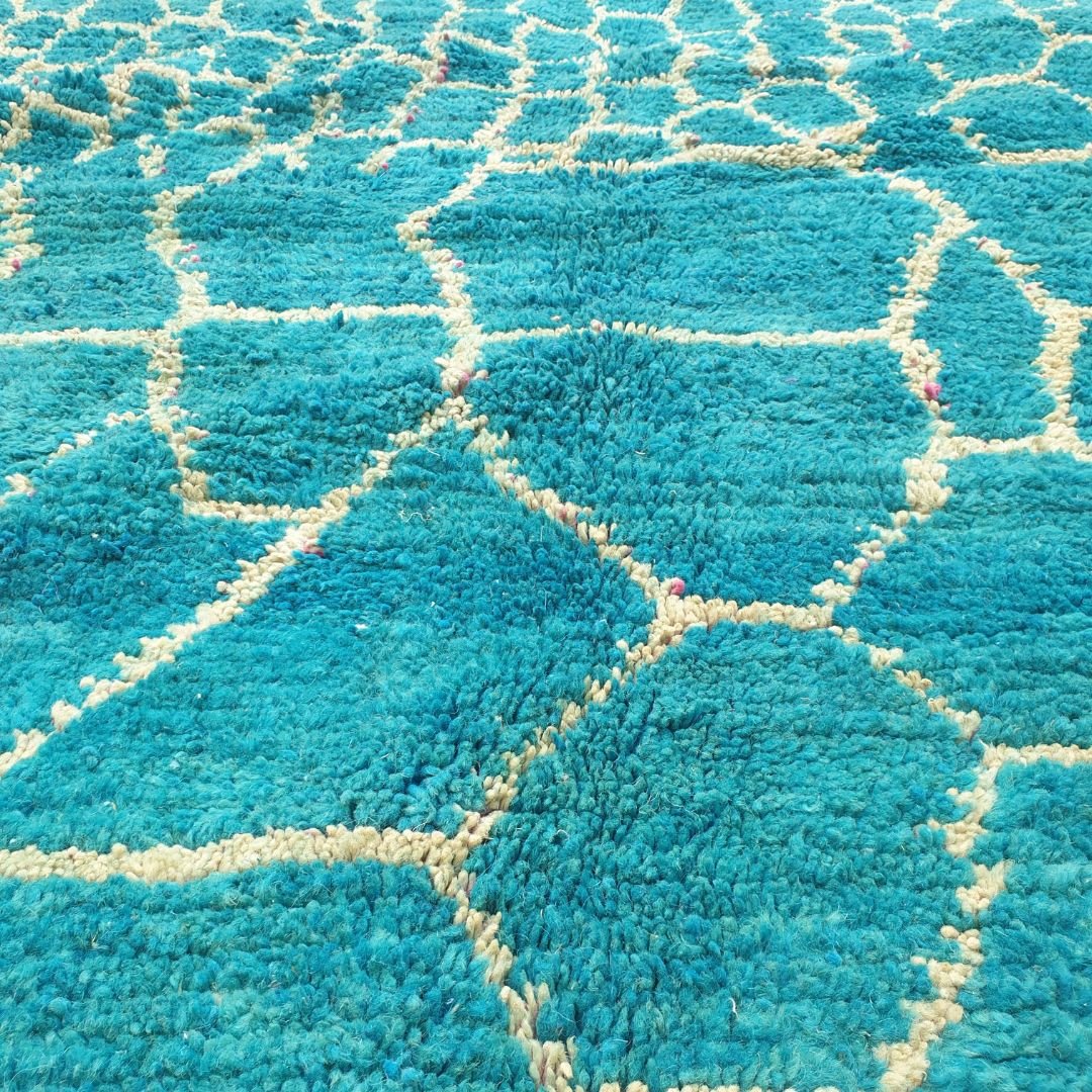 Detailed repeating honeycomb hexagons and geometric motifs in deep teal and ivory on authentic Beni Ourain wool rug, showcasing bold Berber tribal design