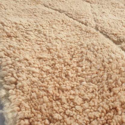 Close-up of a Wynona beige Beni Ourain accent rug showing the soft natural wool pile with the carved diamond and rectangular relief pattern visible only through subtle pile height variation, a tone-on-tone composition handwoven in 100% natural wool